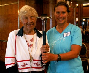 Greta Anderson, swimming legend, holding the World Harmony Run Torch